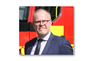 Simon Dennis standing in front of a fire engine