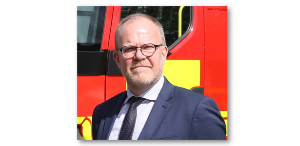 Simon Dennis standing in front of a fire engine